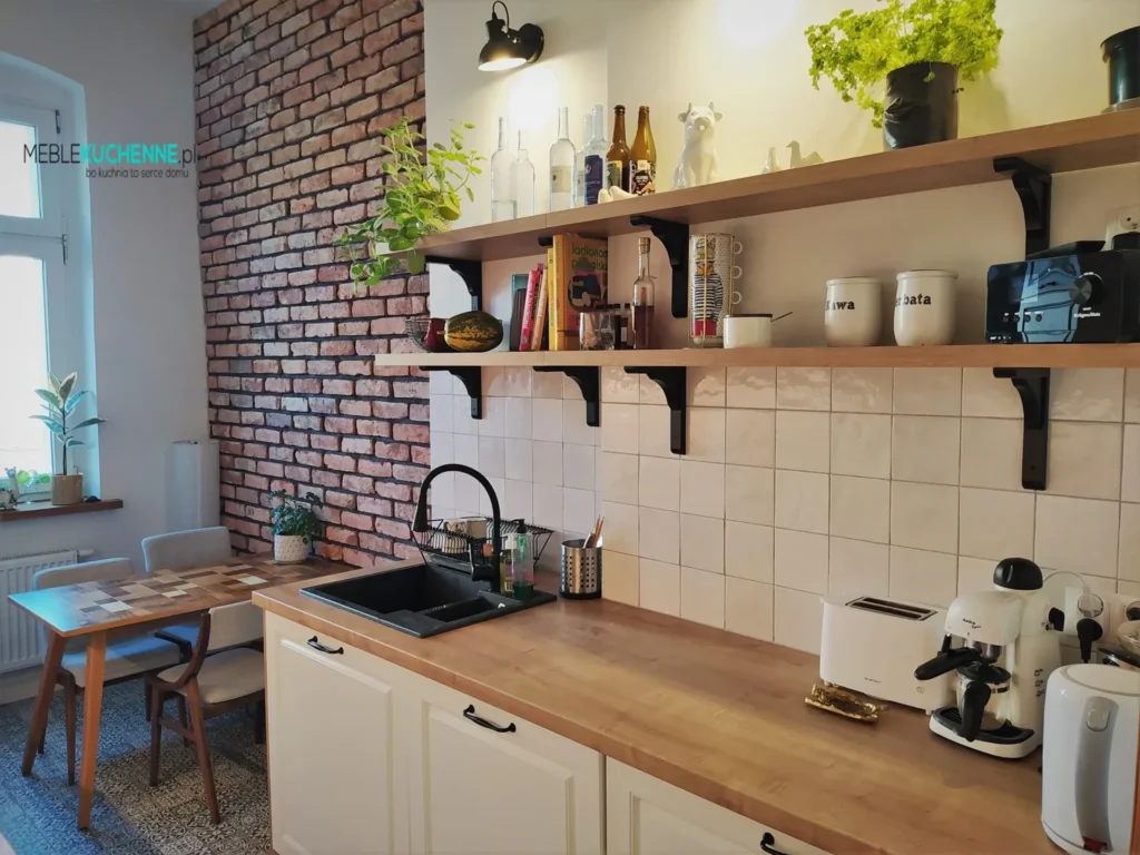 Kuchnie nowoczesne – co na ścianę nad blatem, cegła dekoracyjna, białe płytki i drewniane otwarte półki z czarnymi wspornikami
